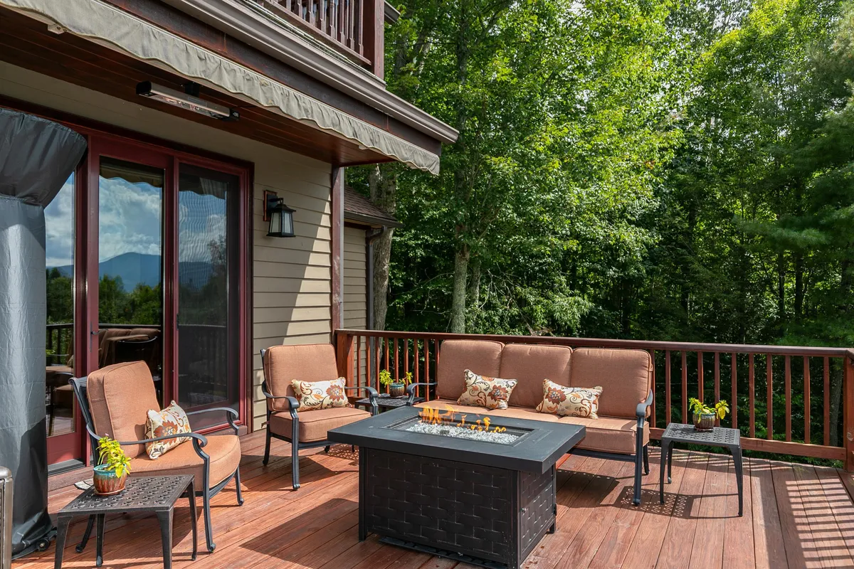 An inviting fire pit with a circle of comfortable seating, set amidst rich greenery. The setup encourages gathering for social activities like roasting s’mores or sharing stories under the stars, set against a backdrop of natural beauty.