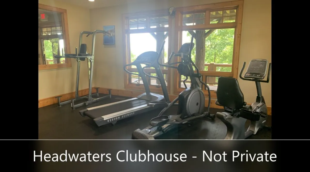 The clubhouse fitness center with treadmills, an elliptical machine, and an exercise bike is illuminated by large windows that let in plenty of natural light, providing views outside. The space is modern, motivating, and designed for both solo workouts and group fitness activities.
